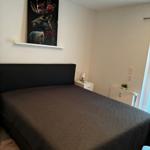 Schlafzimmer mit Bett, Nachttisch und Wandbild