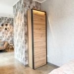 Schlafzimmer mit Bett, Kleiderschrank und Sofa im Hintergrund.