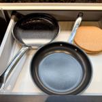 Küchen-Schublade mit zwei Pfannen und zwei Korkuntersetzern.