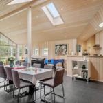 Large space with dining area, game table, and kitchen. Wooden ceiling and large windows.