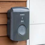 Outdoor electric vehicle charging point mounted on wooden wall