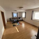 Living room with sofa, coffee table, and windows.
