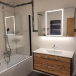 Bathroom with shower, sink, and illuminated mirror