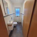 Bathroom with sink, toilet, and window