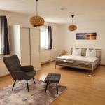 Bedroom with bed, armchair, and wall art