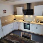 Kitchen with white cabinets, wooden surfaces, and built-in oven.