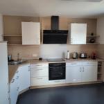 Kitchen with white cabinets, wood finish, and stainless steel sink.