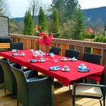 Terrasse mit gedecktem Esstisch, Grill und Bergblick.