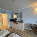 Schlafzimmer mit Schreibtisch, Spiegelschrank und Kleiderschrank im Hintergrund.