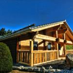 Holzhaus mit Balkon und Dachüberstand in ländlicher Umgebung