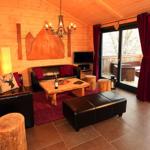 Wohnzimmer mit Holzwand, Ledersofa, Holztisch und Terrasse mit Blick.