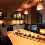 Essbereich mit Tisch, Stühlen und Kamin. Küche mit Schränken und Arbeitsfläche.