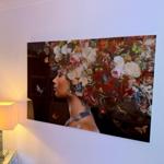 Ein Wandbild zeigt eine Frau mit Blumen und Schmetterlingen. Eine Lampe steht daneben.