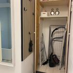 Eingangsbereich mit Garderobe, Staubsauger und Wäscheständer.