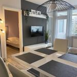 Essbereich mit Tisch und Stühlen, Fernseher an Wand, Blick in Schlafzimmer.