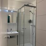 Badezimmer mit Dusche und Waschbecken
