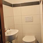 Badezimmer mit Toilette, Waschbecken und Teppichboden.