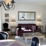 Wohnzimmer mit Sofa, Couchtisch und Stühlen. Hängelampe und Wandspiegel sichtbar.