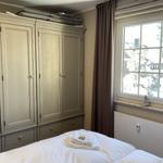 Schlafzimmer mit großem Schrank und Fensterblick auf schneebedeckte Bäume.