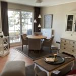 Essbereich mit runden Tisch, vier Stühlen und Glasfront zur Terrasse.