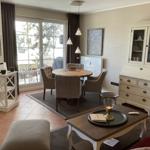 Esszimmer mit runden Tisch, vier Stühlen und Glasfront zur Terrasse.