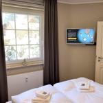 Zimmer mit Doppelbett, Fenster mit Blick auf Schnee, TV und Handtücher.