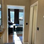 Durchgang mit Blick in Wohnzimmer mit Sofa und Fenstern.