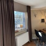 Raum mit Fenster, Vorhängen und Esstisch. Draußen Schnee. Wand mit Hirschgeweih.