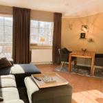 Wohn- und Essbereich mit Sofa, Tisch und Blick auf verschneite Berge.