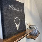 Gästebuch mit Hirschmotiv und Buchstabe B auf Holzregal