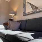 Ein Sofa mit Kissen und einem Spiegel an der Wand.