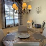 Rundes Esszimmer mit Holztisch, Stühlen und Deckenleuchte. Wanddekoration mit Hirschgeweih.