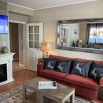 Ein Wohnzimmer mit rotem Sofa, Kamin und Fernseher. An der Wand hängt ein großer Spiegel.