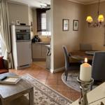 Wohn- und Essbereich mit Küchenzeile und Esstisch mit Kerze.