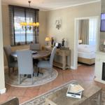 Essbereich mit Tisch und Stühlen, Wohnbereich mit Couchtisch und Blick in Schlafzimmer.