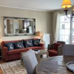 Wohnzimmer mit Sofa, Tisch und Spiegel an der Wand.