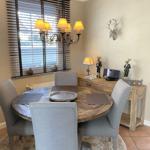 Rundes Esszimmer mit Holztisch, grauen Stühlen und dekorativen Hirschfiguren an der Wand.