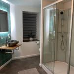 Badezimmer mit Dusche, Waschbecken und Fenster