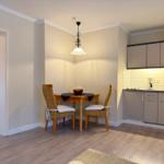 Küche mit Essbereich, Holztisch, zwei Stühle und integrierte Küchenschränke.