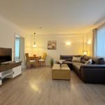 Wohn- und Essbereich mit Sofa, TV und Holzboden.