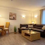 Wohn- und Essbereich mit Sofa, Esstisch und Glas-Tisch.