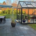 Terrace with seating and glass structure in the background.