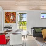 Dining area with round table and chairs next to a living area with sofa and window.