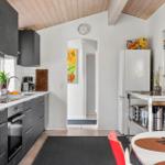 Kitchen with worktop, fridge, and dining table with chairs.