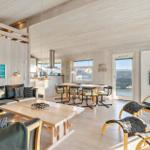 Living and dining area with wooden furniture and view to the terrace.