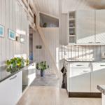 Kitchen with wooden walls, countertop, and staircase to upper level.