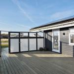 Deck with wooden flooring and black mesh fence. Background shows a landscape with rooftops.