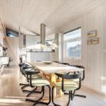 Dining area with table and chairs, kitchen, and window to outdoor terrace.