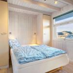 Bedroom with bed, wardrobe, and window overlooking outside.