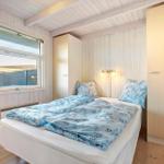 Bedroom with bed, window, and closets. Wooden walls and floor.